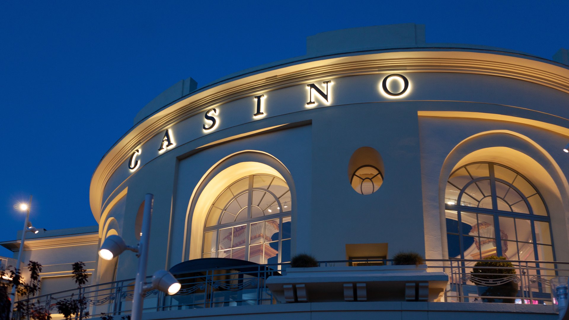 Vue extérieure du casino de Royat de nuit, illuminé dans un cadre élégant et accueillant, parfait pour une soirée de divertissement.